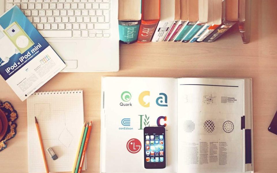 Una scrivania con libri e stampe colorate